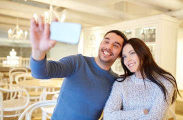 couple taking smartphone selfie at cafe restaurant