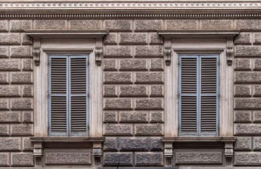 Two windows with closed shutters.