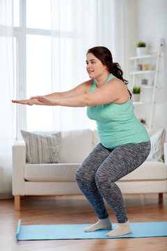 Plus Size Woman Exercising On Mat At Home