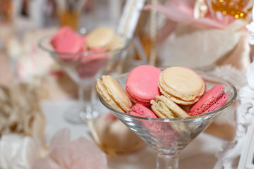 Fototapeta na wymiar Sweet colored macaroons in glasses, on the holiday table