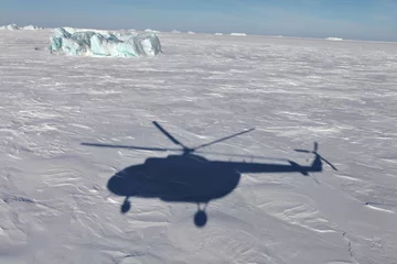 Abwaschbare Fototapete Nördlicher Polarkreis Luftaufnahme des Eisbergs im gefrorenen Arktischen Ozean und Hubschrauberschatten