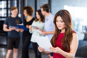 Woman reading a document in office