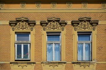 Obraz premium Three windows with flowers in one of them