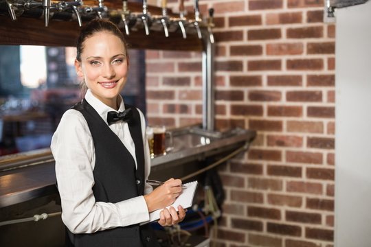 Barmaid taking orders on notepad