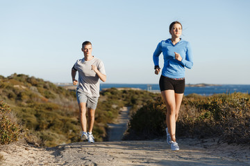 Fototapeta premium Sport runner jogging on beach working out with her partner