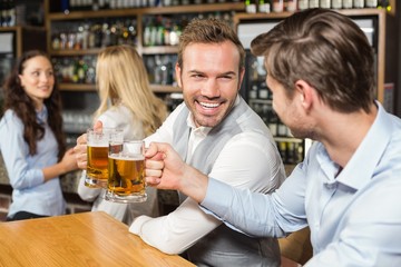 Men toasting in front while women talk behind