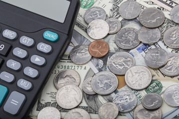 USD bank notes with coins and a calculator