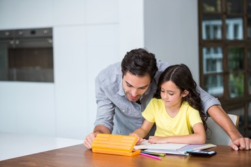 Father assisting daughter with homework