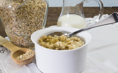 Bowl of cooked rolled oats with milk and honey