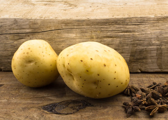 Two potatoes close up on wood with star anise