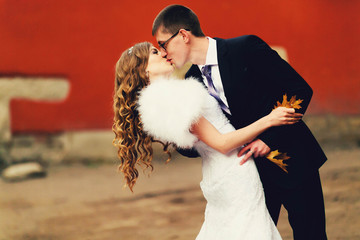 luxurious stylish young bride and groom on the background of aut