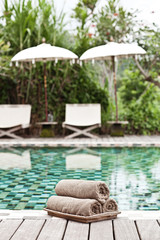 Brown towels in wicker basket at a luxury swimming pool