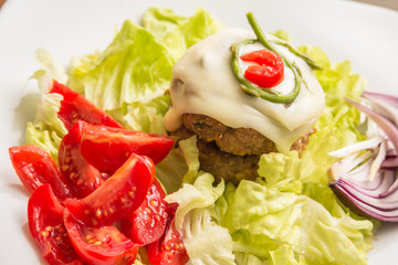 Double beef burger with melted cheese, asparagus and fresh vegetables