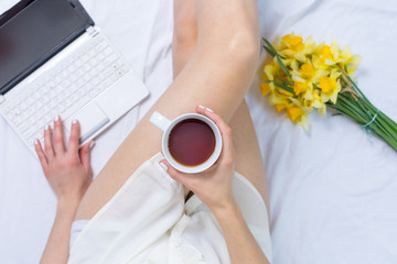 Obraz na płótnie Canvas Woman having a cup of tea in bed