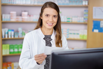 freundliche apothekerin hält ein rezept in der hand