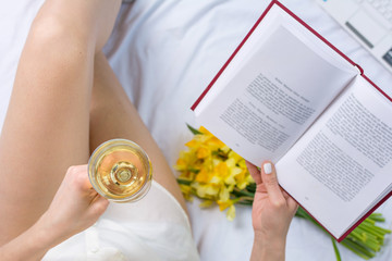 Woman having a glass of wine in bed