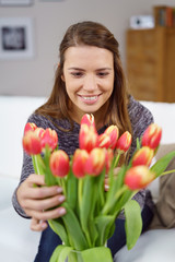 frau freut sich über einen strauß tulpen