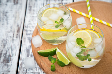 Fresh cocktail with soda, lime and lemon on a wooden background