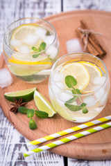 Fresh cocktail with soda, lime and lemon on a wooden background