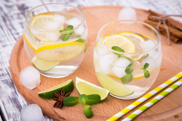 Obraz na płótnie Canvas Fresh cocktail with soda, lime and lemon on a wooden background