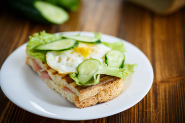 sandwich with sausage, cheese, lettuce and eggs