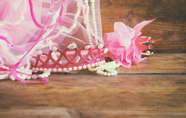 Small girls party outfit: crown and vail on wooden table. bridesmaid or fairy costume.
