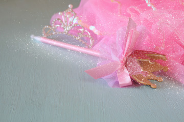 Small girls party outfit: crown and wand on wooden table. bridesmaid or fairy costume © tomertu
