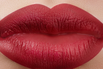 Close-up of woman's lips with fashion red make-up. Beautiful female mouth, full lips with perfect makeup. Classic visage. Part of female face. Macro shot of beautiful make up on full lips.