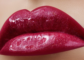 Close-up of female lips with bright makeup. Macro of woman's face. Fashion lip make-up with red gloss