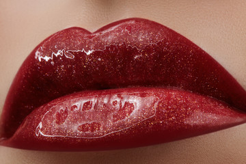 Close-up of female lips with bright makeup. Macro of woman's face. Fashion lip make-up with red gloss