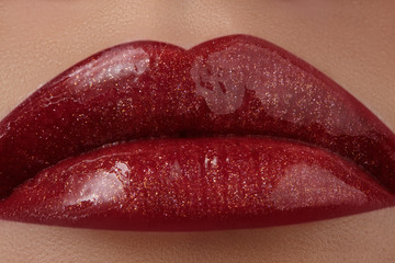 Close-up of female lips with bright makeup. Macro of woman's face. Fashion lip make-up with red gloss