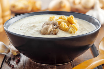 Mushroom cream soup on a brown wooden table, European food