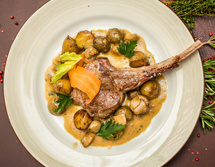 Grilled lamb served on white plate with vegetables