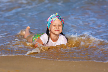 Happy child girl play and having fun in the water at the beach. Selective focus.