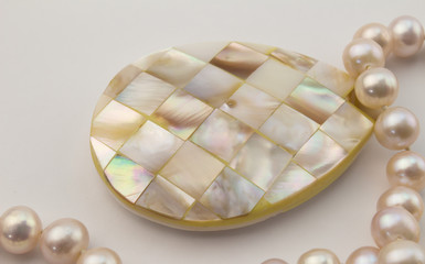 Pearl necklace with mother of pearl inlay pendant isolated on wh