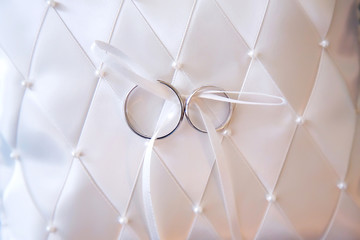 Engagement gold rings on white pillow