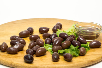 Olive olive oil on a wooden board, and lettuce isolated