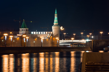 View to embankment of the river, Moscow Kremlin's wall and tower with full moon on background from another side of the river in the night, autumn 2015