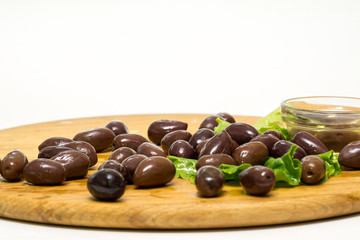 Olive olive oil on a wooden board, and lettuce isolated