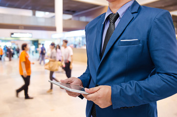 businessman using tablet with blurred event background