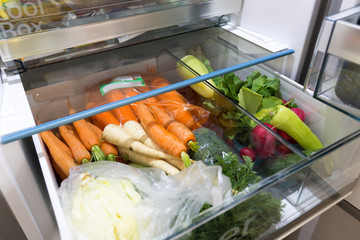 Open fridge filled with vegetables
