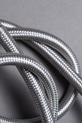 Braided stainless steel water hose over grey background