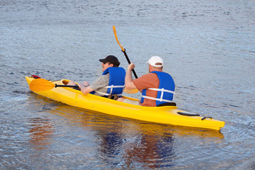 Two Men Kayaking – Two adult males in a yellow kayak.