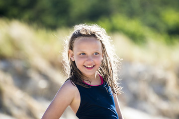 Naklejka premium Happy smiling girl at the beach, with beautiful lighted wet hairs.