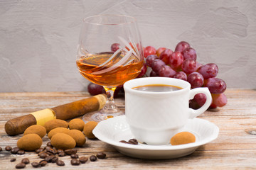 Cigar, brandy, cup coffee espresso with chocolate eggs and grape
