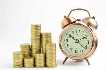 gold coins stack and alarm clock on white background