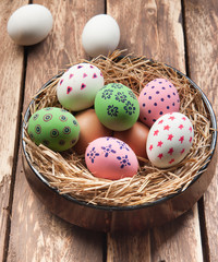 Easter eggs in nest on wooden background