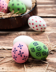 Easter eggs in nest on wooden background