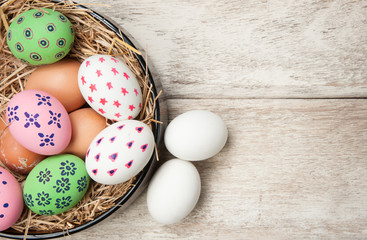 Easter eggs in nest on wooden background