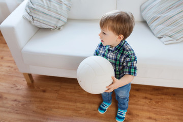 happy little baby boy with ball at home